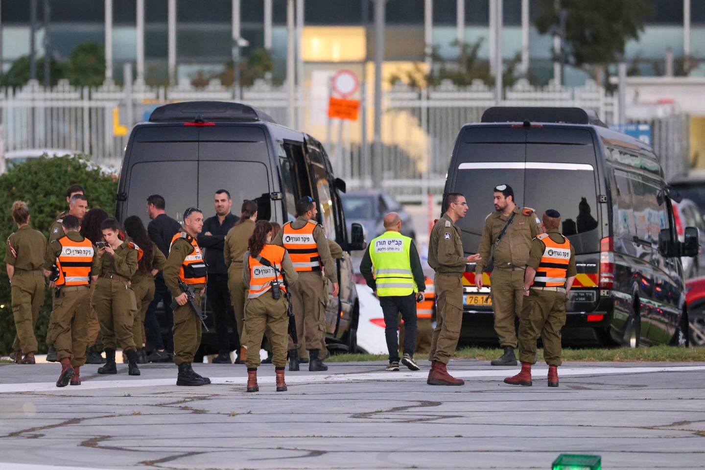 Des personnels des forces de sécurité israéliennes à côté des bus devant l'héliport de Tel Aviv Schneider. 