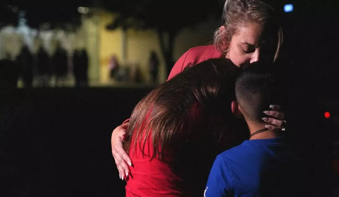 Des familles s'enlacent après une fusillade dans une école primaire, le 24 mai 2022 à Uvalde, au Texas.
