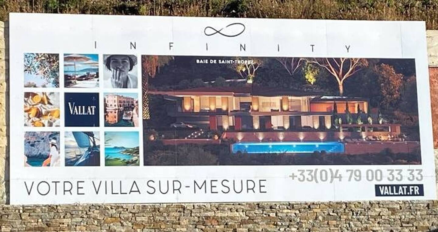 Une image de l’une des futures villas s’affiche sur la pancarte installée sur les lieu des travaux.