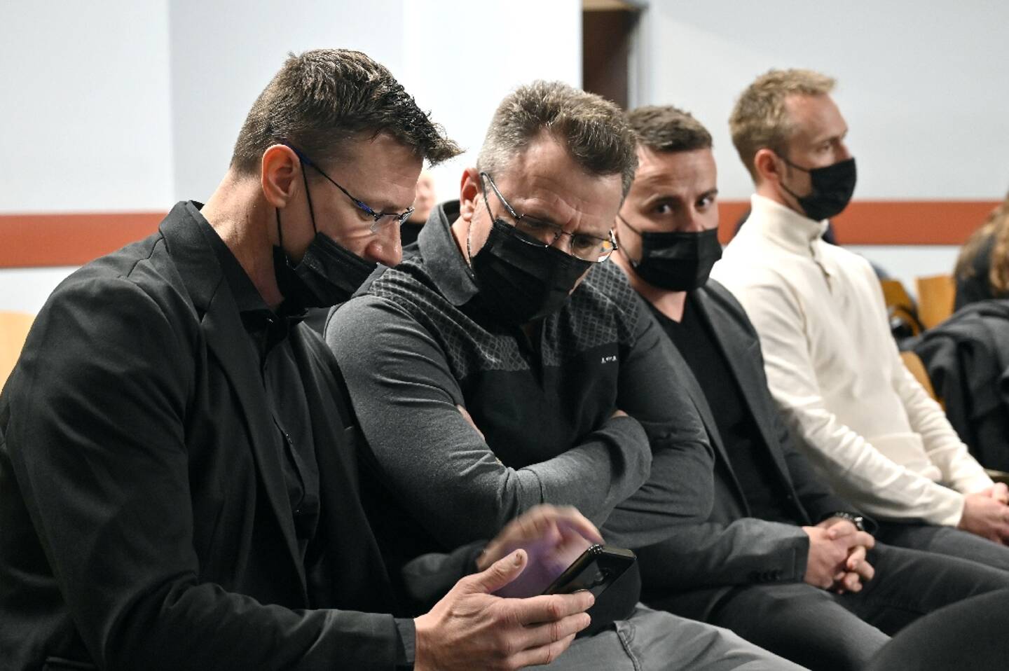 L'ancien footballeur international Tony Vairelles (à gauche) et ses frères Fabrice, Giovan et Jimmy (de gauche à droite) attendent au tribunal correctionnel de Nancy le 21 mars 2022, avant leur procès pour "violences aggravées".