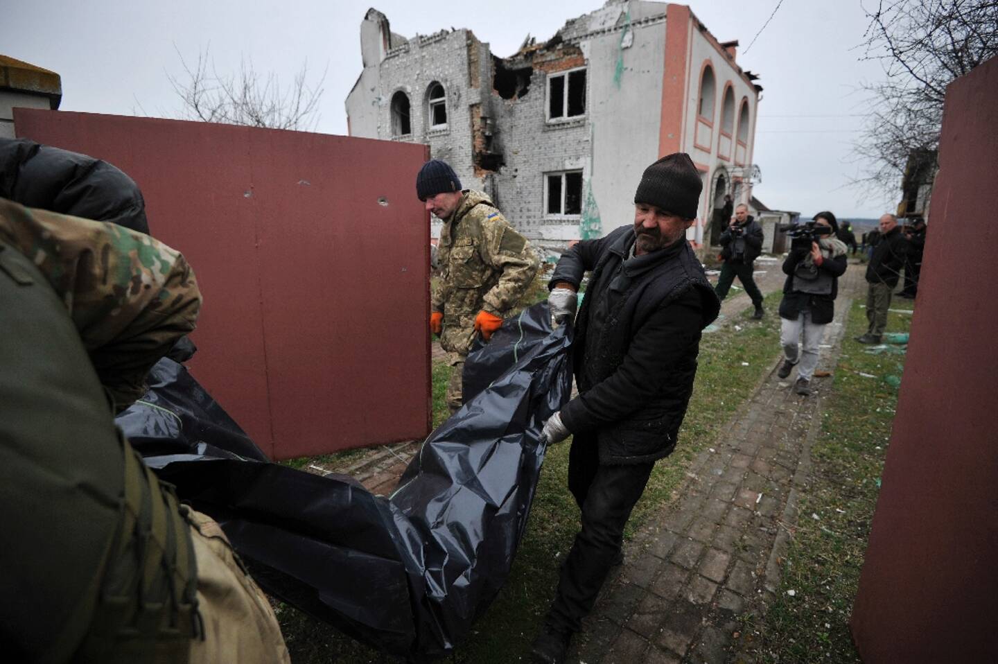 Rescue workers carry the body of a victim in Andriivka, near Kiev, on April 11, 2022 in Ukraine.
