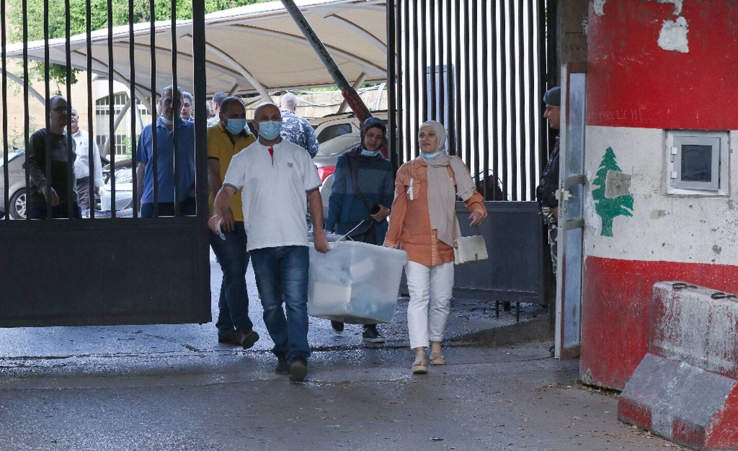 Des fonctionnaires libanais transportant des urnes scellées vers un bureau de vote à Sidon, dans le sud du pays, le 14 mai 2022