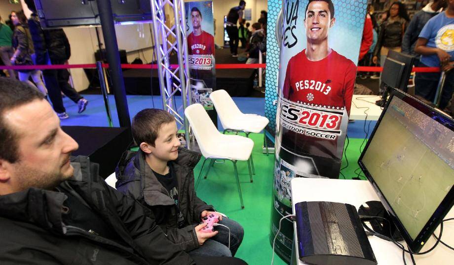 Adulte et enfant, c'est un peu la totalité du public qui se retrouve sur les jeux vidéo qu'ils soient en ligne ou pas. Ici, un jeu de simulation de foot sur le stand de PES.