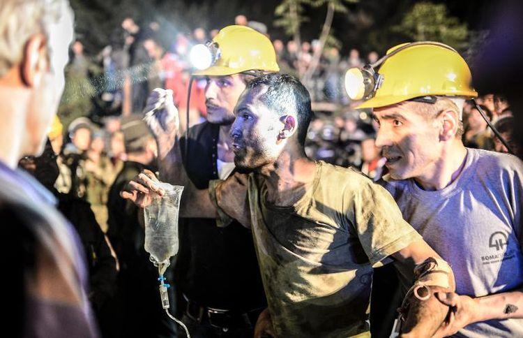 Un mineur est extrait de terre, entouré par des secouristes, après une explosion dans une mine de charbon de la province de Manisa, en Turquie, le 13 mai 2014 (Photo Bulent Kilic. AFP)