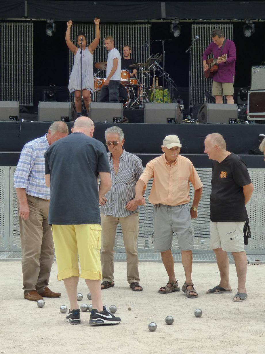 Des joueurs de boules poursuivent leur partie, imperturbables, pendant que l'artiste Susheela Raman répète son spectacle pour le Festival des Nuits du Sud, ce vendredi à Vence.  