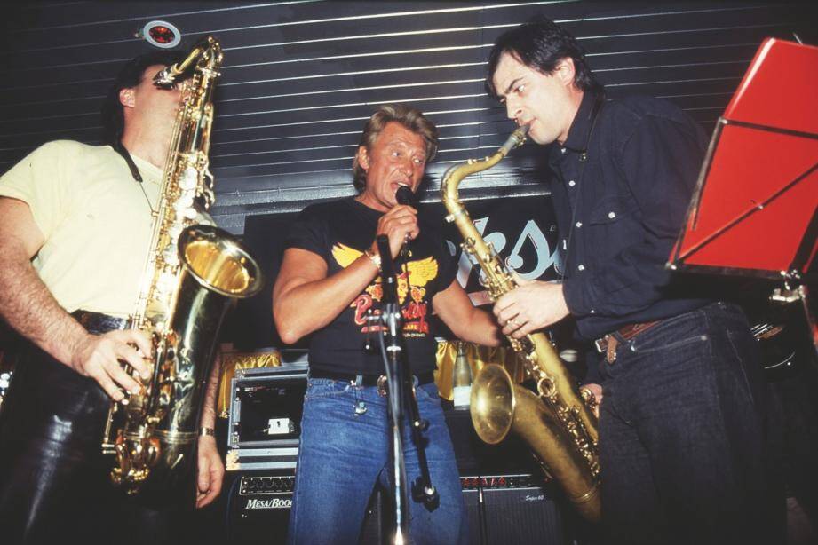 Johnny Hallyday joue avec quelques musiciens.