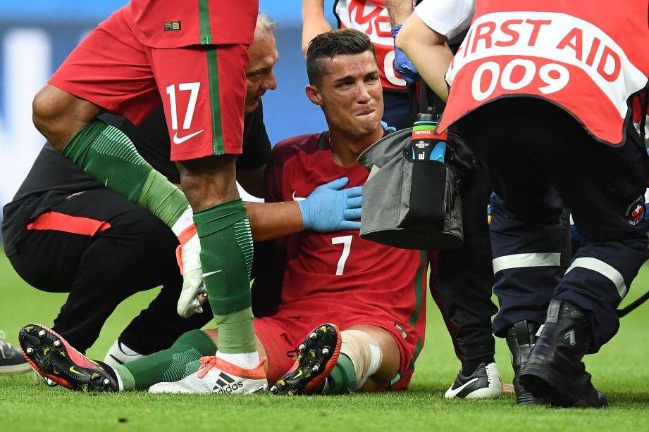 Portugal's forward Cristiano Ronaldo reacts as medics arrive on the pitch during the Euro 2016 final football match between France and Portugal at the Stade de France in Saint-Denis, north of Paris, on July 10, 2016. / AFP PHOTO / FRANCK FIFE FBL-EURO-2016-MATCH51-POR-FRA