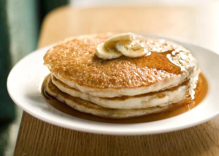 Banana pancakes in a pool of maple syrup.  Photographed for a restaurant review in Honolulu Magazine.