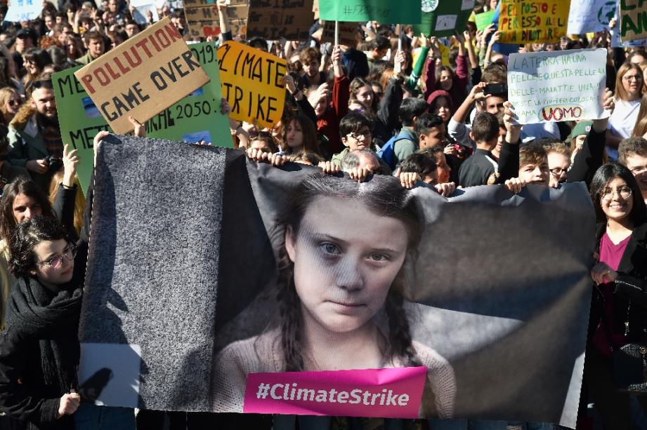 Des manifestants tiennent une banderole avec le portrait de l'activiste environnementale Greta Thunberg, à Rome le 15 mars 2019