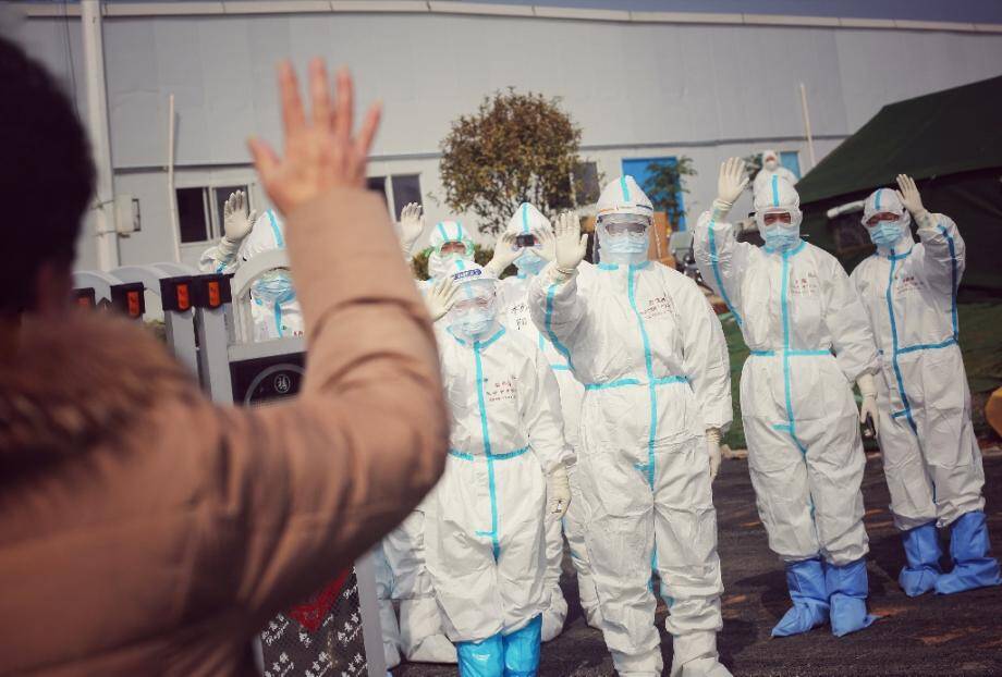 Des membres de l'équipe médicale disent au revoir, le 1er mars 2020, à une patiente guérie du coronavirus, dans l'un des hôpitaux provisoires de Wuhan installés pour faire face à l'épidémie