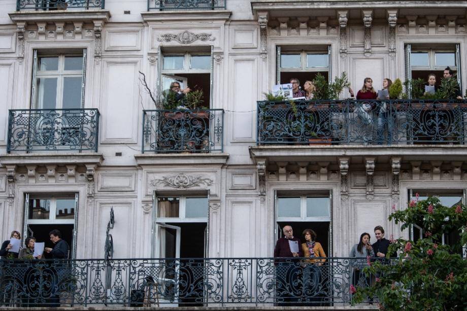 Des parisiens sur leur balcon chantent ensemble, le 1er mai 2020 