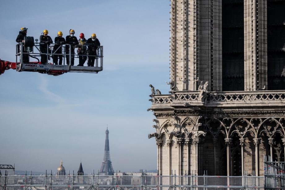 Des ouvriers sur une grue regardent le chantier de la cathédrale Notre-Dame à Paris le 24 novembre 2020