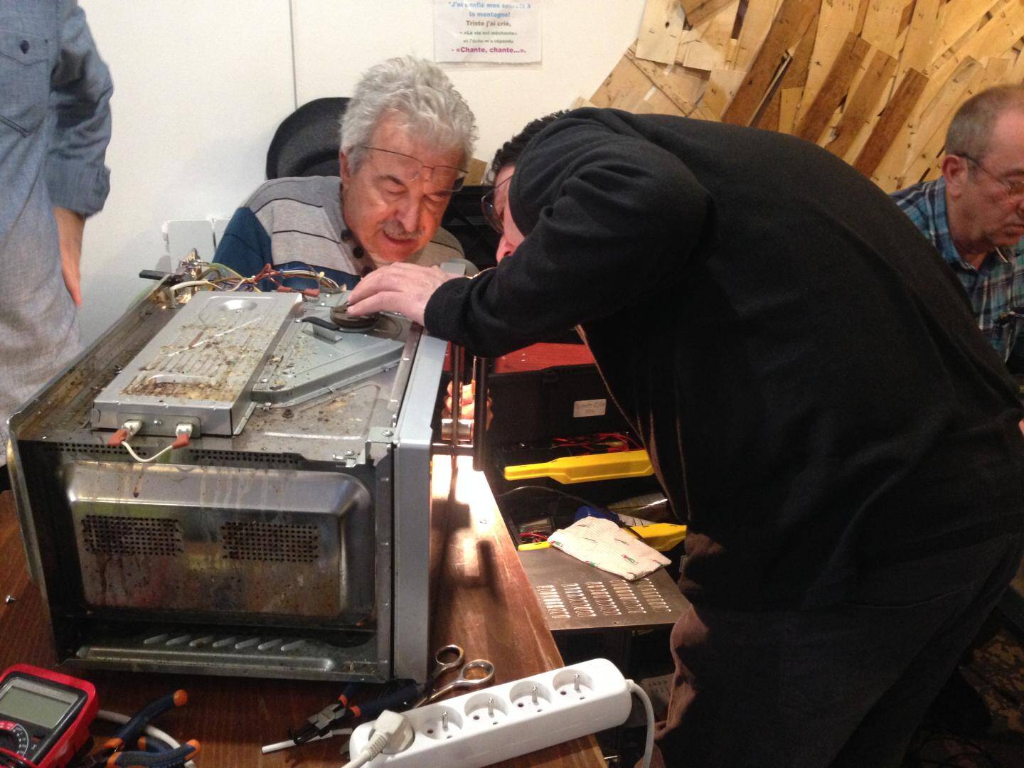 Daniel démonte un micro-ondes au Repair-Café organisé par le Court-Circuit