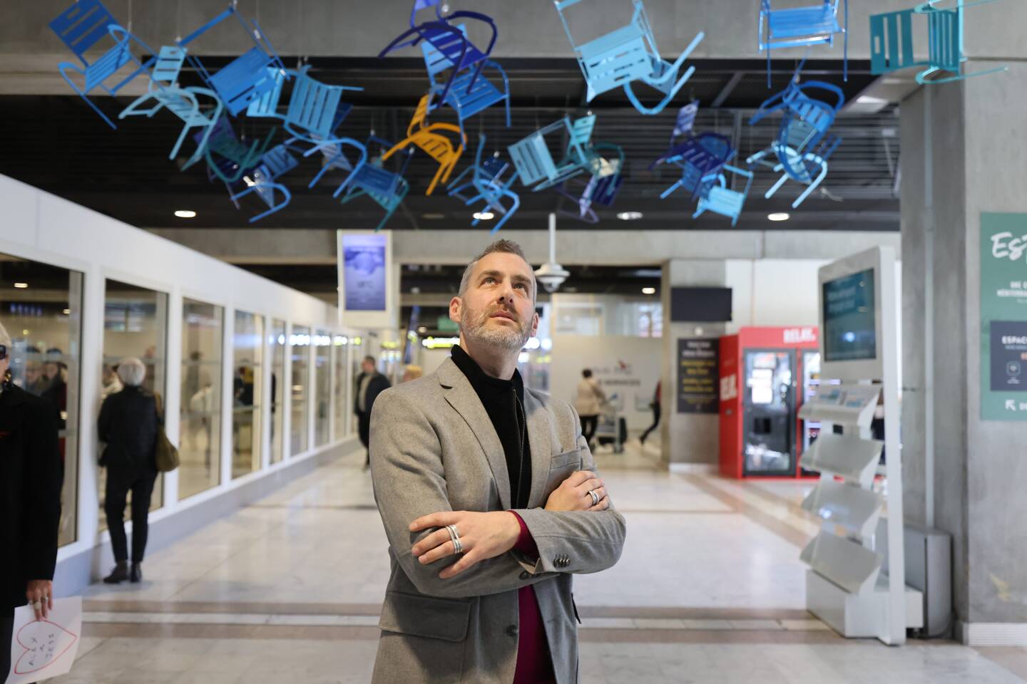 L’artiste niçois Sébastien Di Natale fait voler les chaises bleues à l’arrivée du terminal 2. (Photo Sébastien Botella)