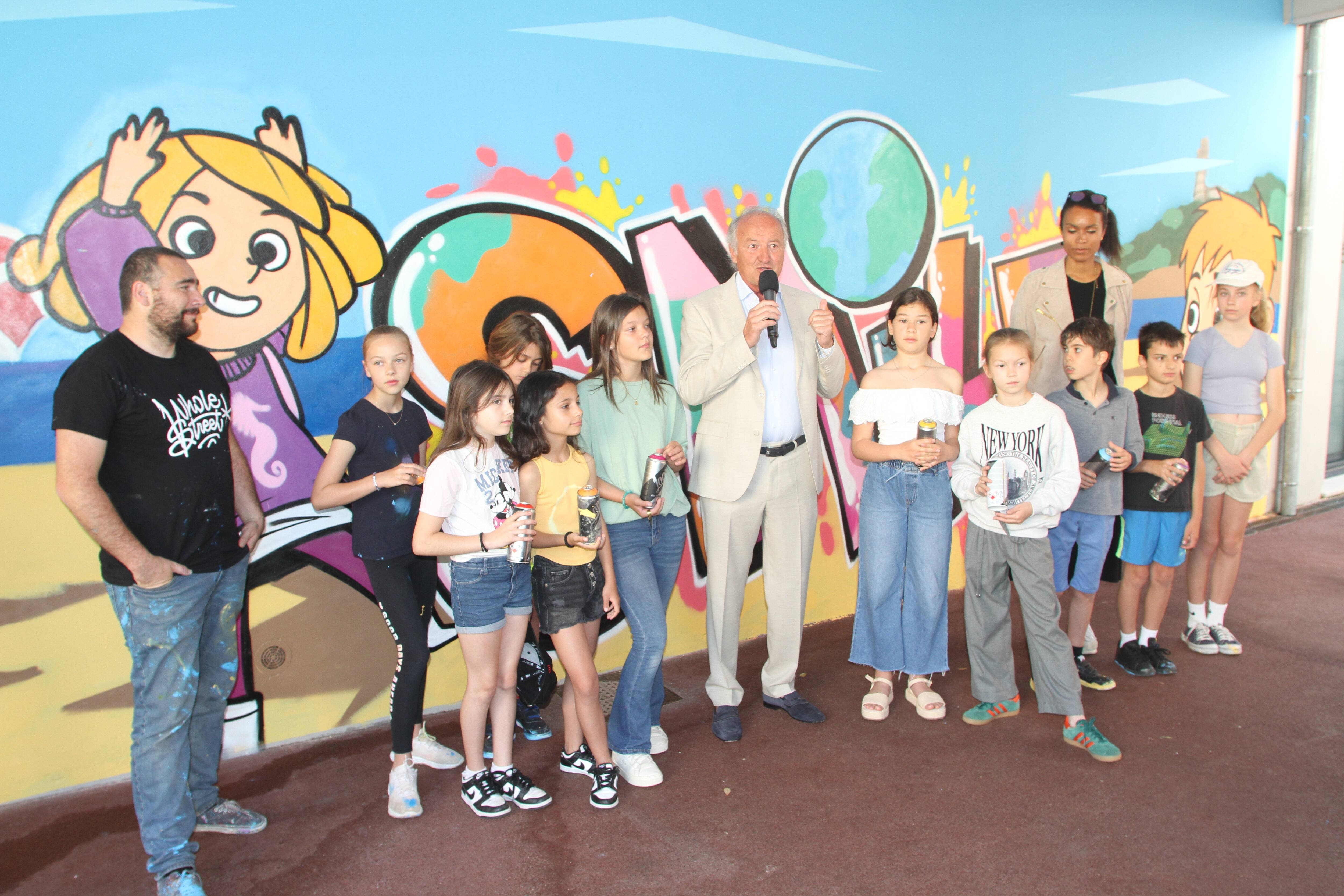 Parents et enfants prennent la craie pour dessiner dans la cour de l'école, à Saint-Jean-Cap-Ferrat